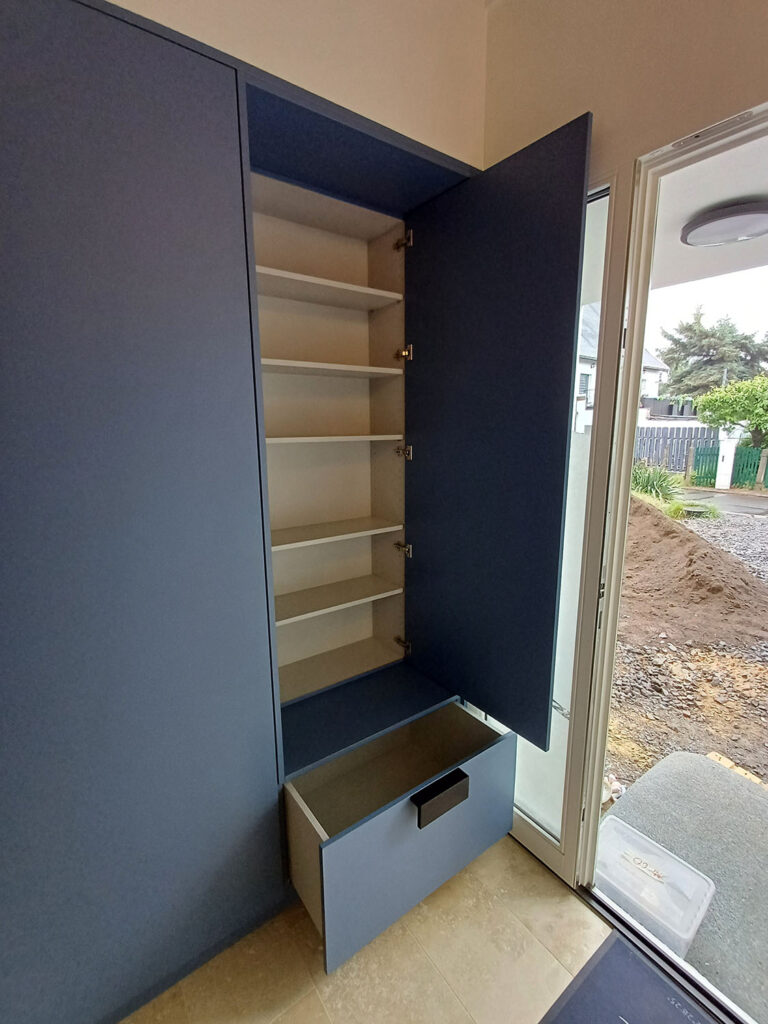 Geöffnete Einbaugarderobe mit Einlegeböden und ausgezogener Schublade