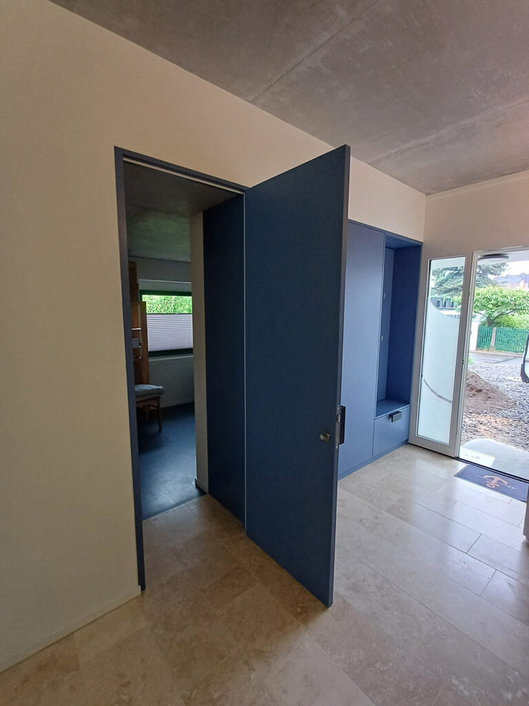 Raumhohe flächenbündige Innentür in Blaugrau, farblich auf die Einbaumöbel abgestimmt